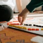 Dłoń dziecka przesuwa pionek na planszy podczas gry strategicznej