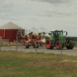 Nowoczesny traktor z przetrząsaczem siana na szwedzkim polu