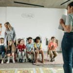 Przedszkolaki różnych narodowości bawią się z nauczycielkami w sali