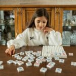 Dziewczynka bawi się edukacyjną grą słowną w domu