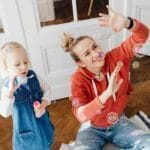 Mama bawi się z córką bańkami mydlanymi w spokojnej domowej atmosferze