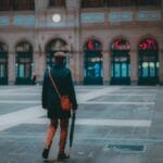 Elegancki mężczyzna w płaszczu spaceruje po francuskim dworcu kolejowym