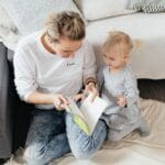 Mama i córka czytają wspólnie interaktywną książkę w salonie