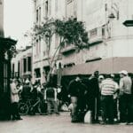 Przechodnie na ruchliwej ulicy przy miejskim kiosku informacyjnym