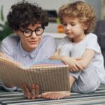 Mama czyta książkę z małym synkiem na dywanie